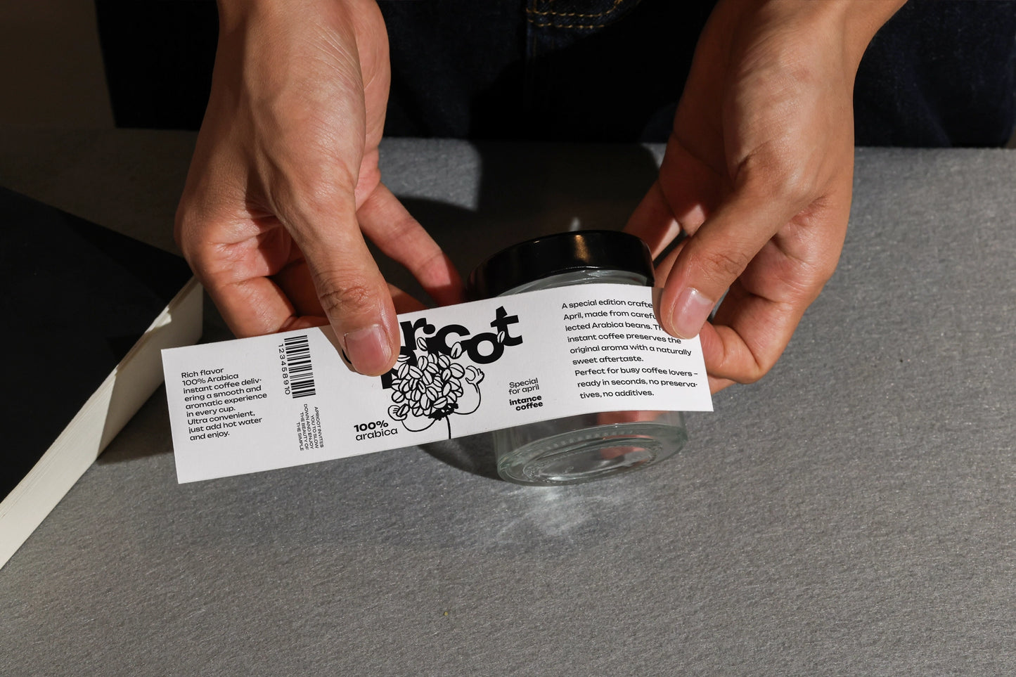 wrap label mockup applied to glass jar with hands close up