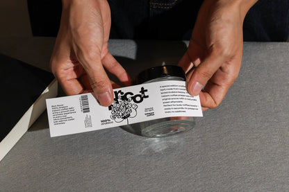 wrap label mockup applied to glass jar with hands close up