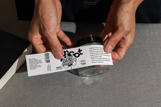 wrap label mockup applied to glass jar with hands close up