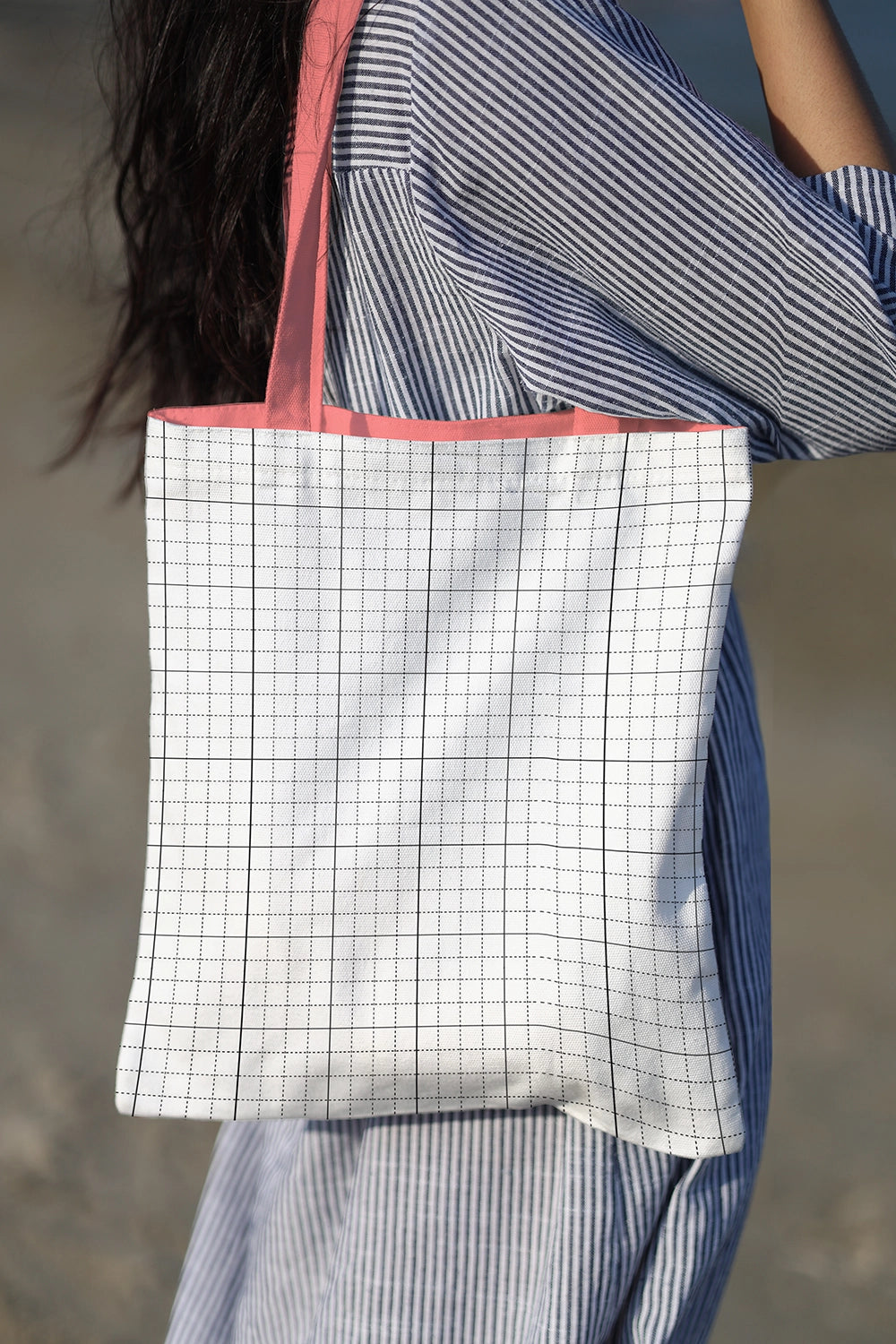 cotton tote bag mockup with character artwork, realistic outdoor lighting and soft shadows