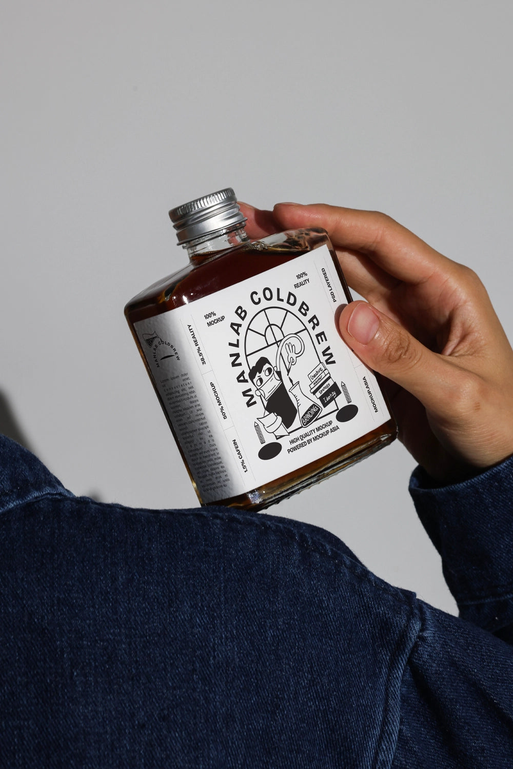 Tilted cold brew bottle mockup held in hand with clean studio background
