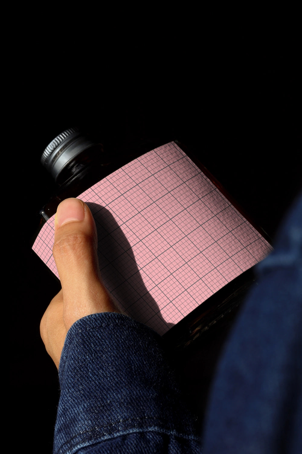Handheld cold brew bottle mockup with cinematic lighting and shadow detail
