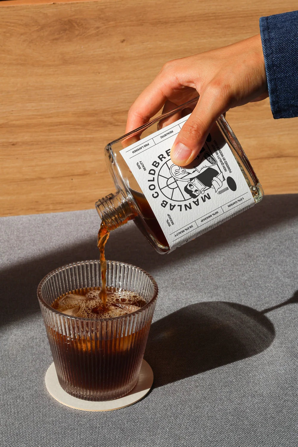 Pouring cold brew bottle mockup into glass with realistic coffee flow and shadow