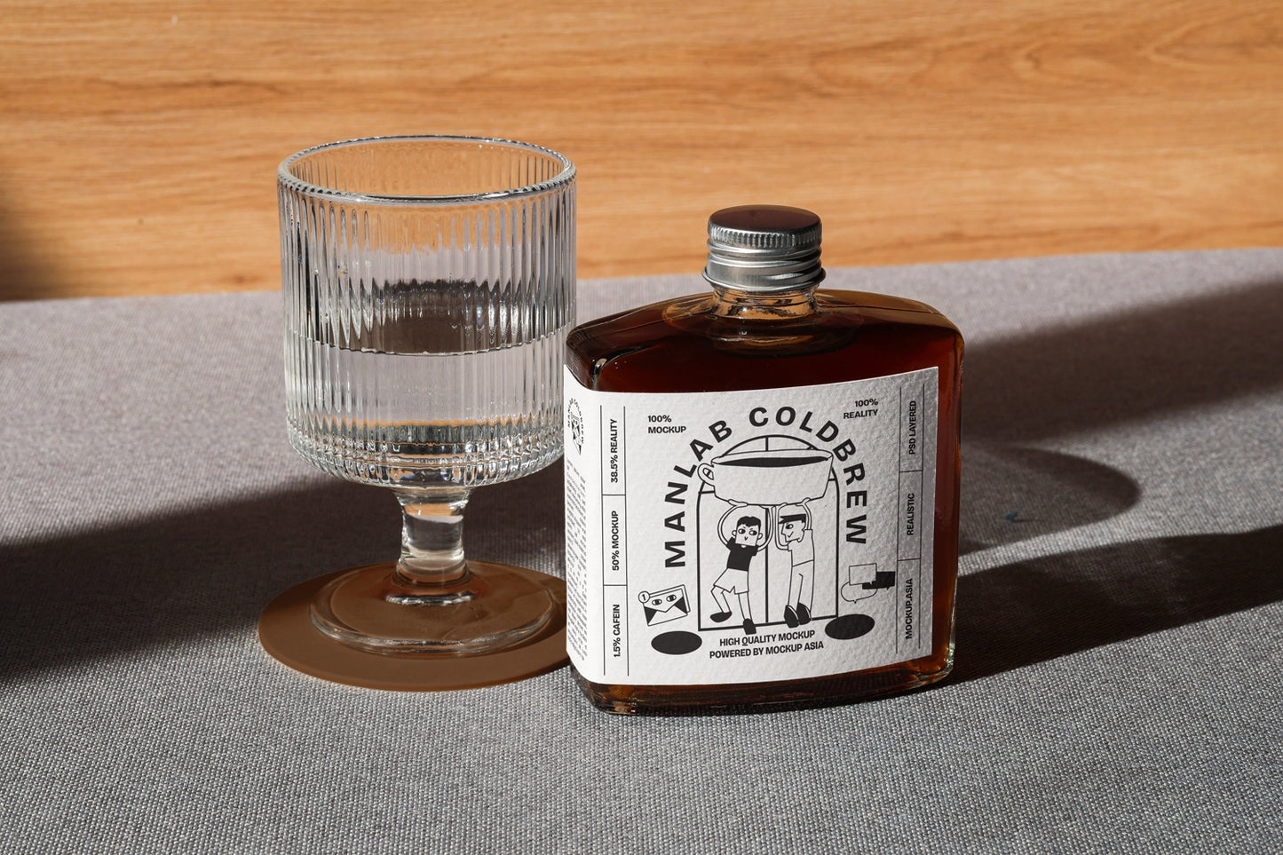 Cold brew bottle mockup with glass in clean lighting and realistic shadow setup
