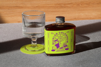 Coffee bottle mockup next to empty glass in minimal lifestyle scene
