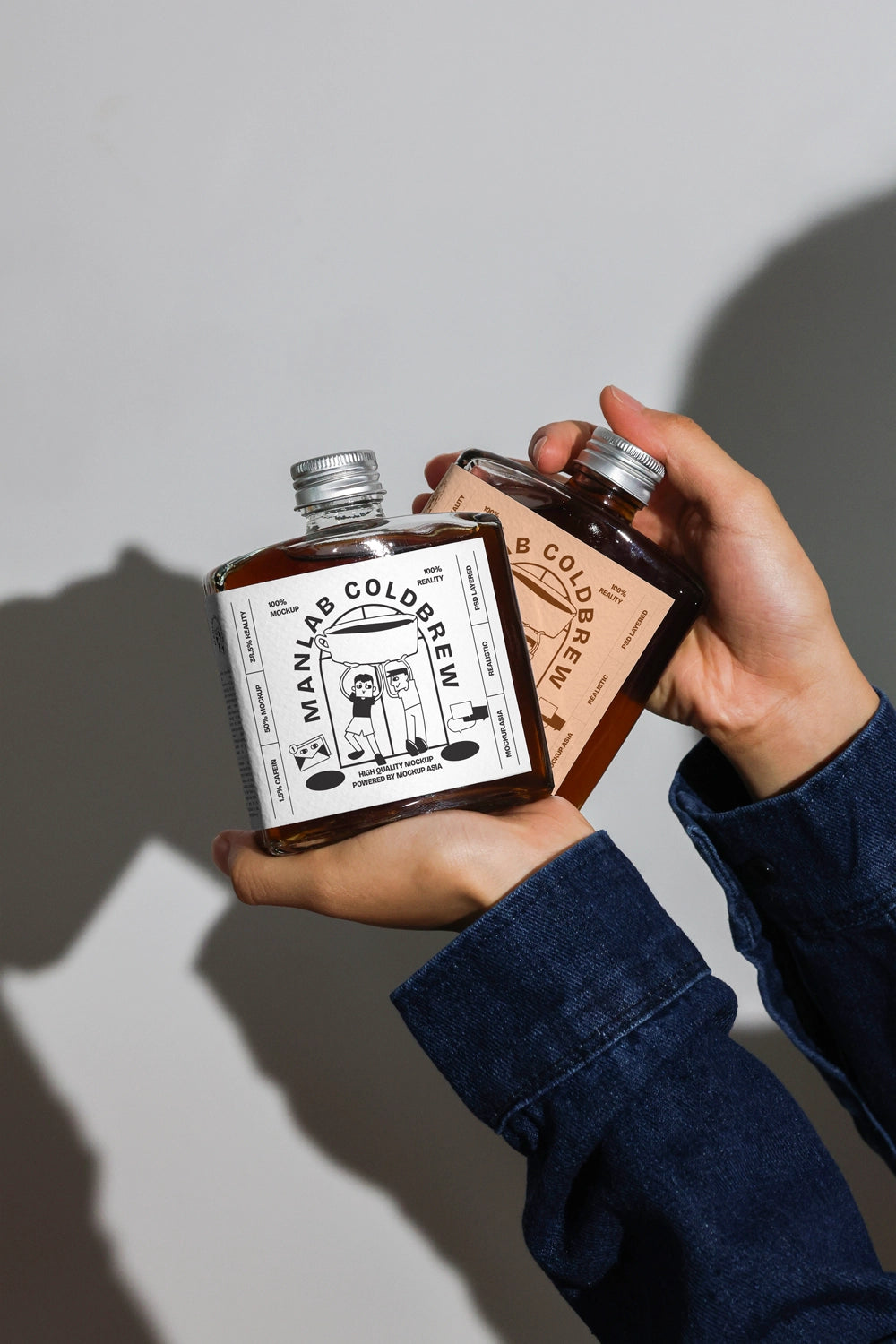 Dual cold brew coffee bottle mockup with different label designs and realistic lighting
