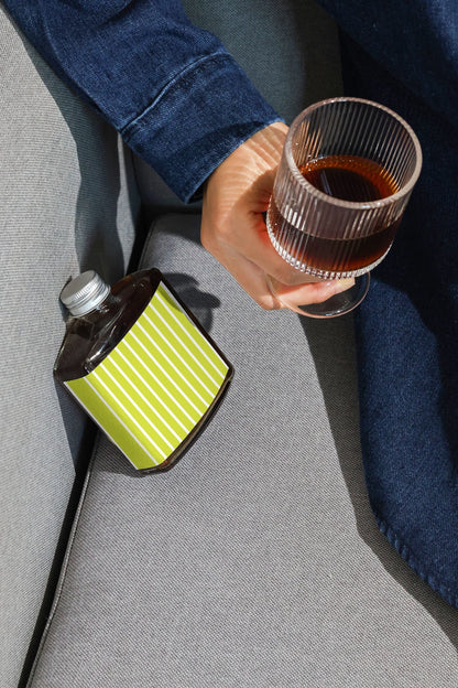 Coffee packaging mockup with hand holding drink and bottle nearby
