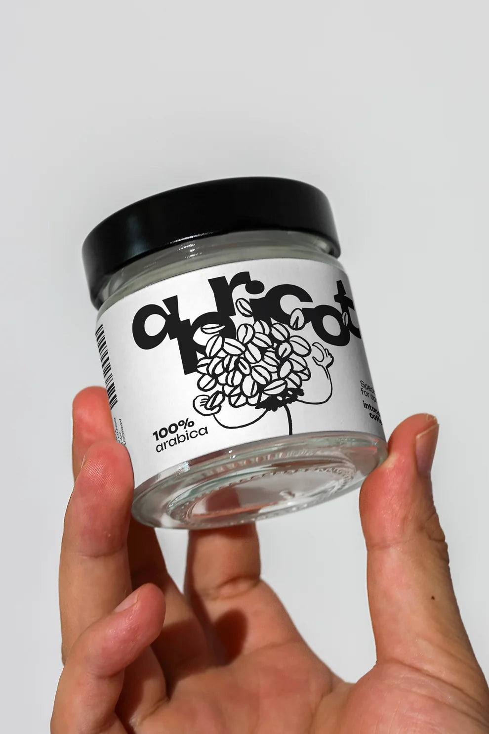 glass jar mockup held in hand with coffee label, minimal product packaging presentation