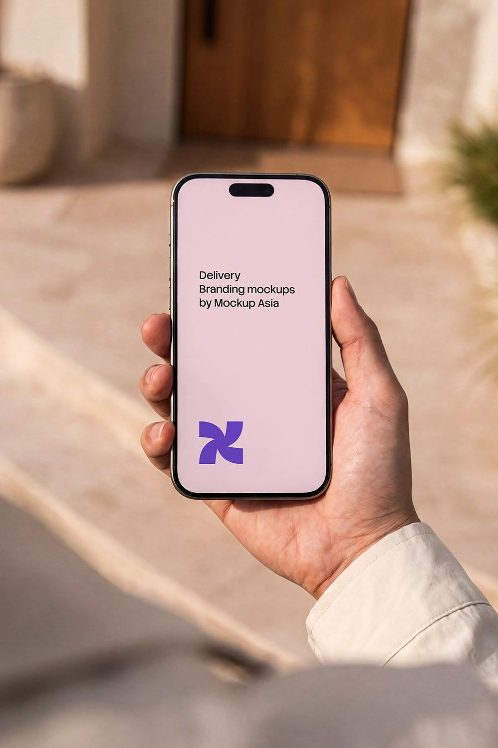 iPhone 16 Pro mockup held in hand outdoors with clean blank screen in natural sunlight