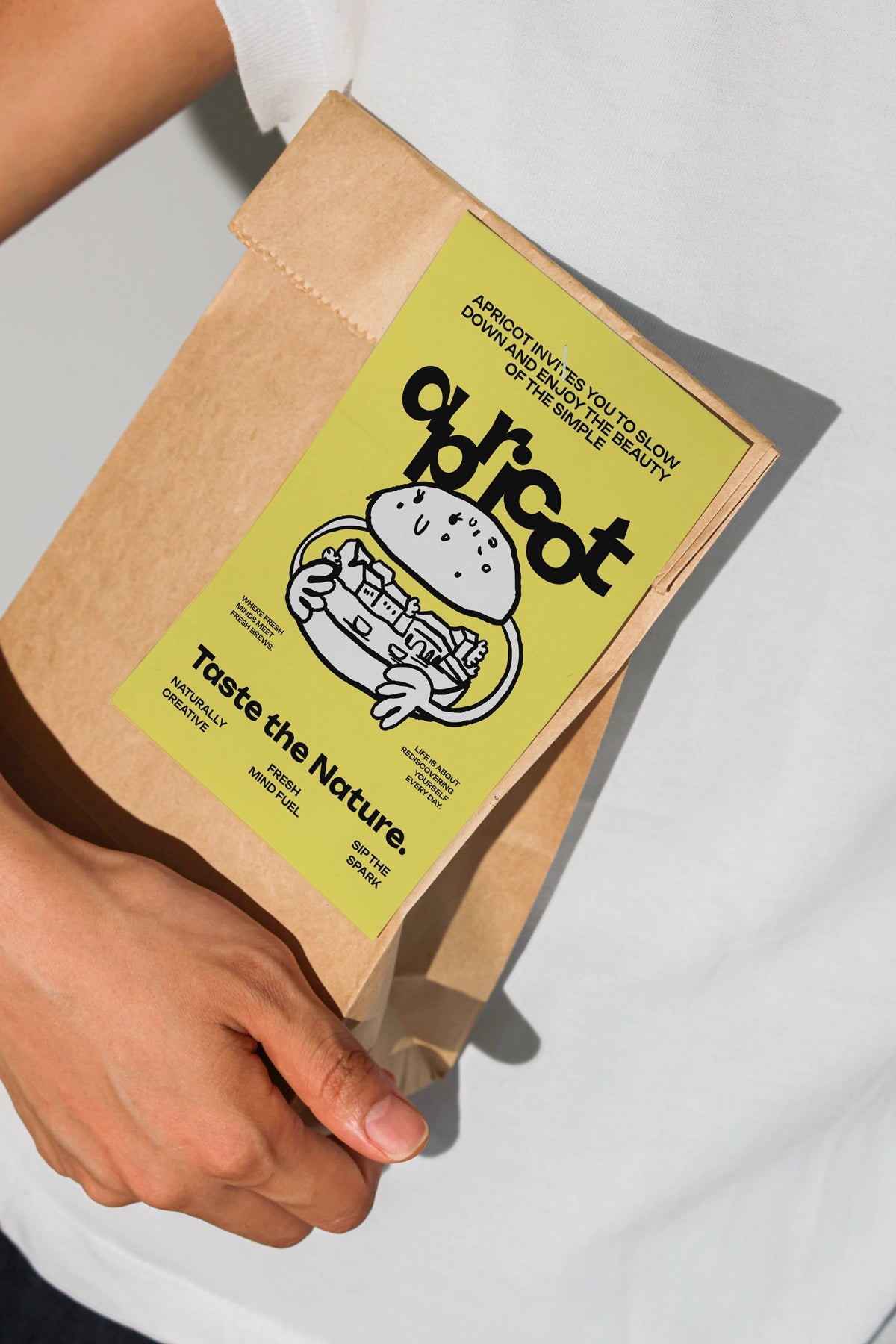 brown paper packaging bag mockup with sticker label, realistic hand-held product presentation