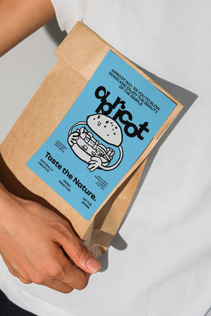 kraft pouch mockup with blank grid label in hand, natural light and shadow aesthetic
