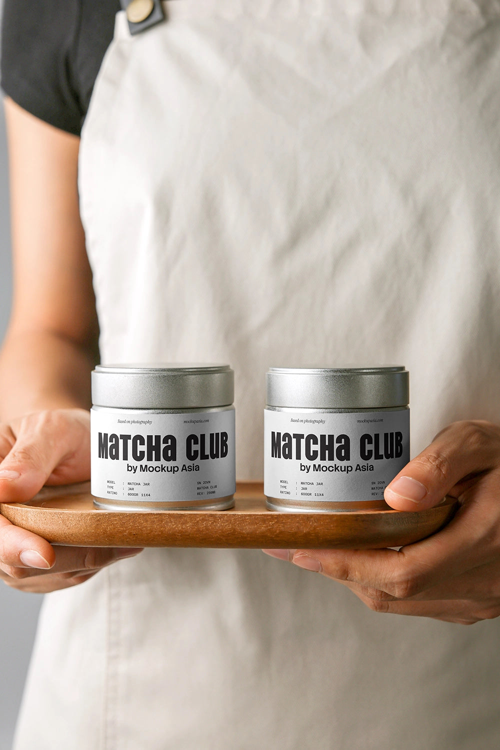 matcha tin mockup set held on wooden tray by hands, minimal lifestyle product presentation