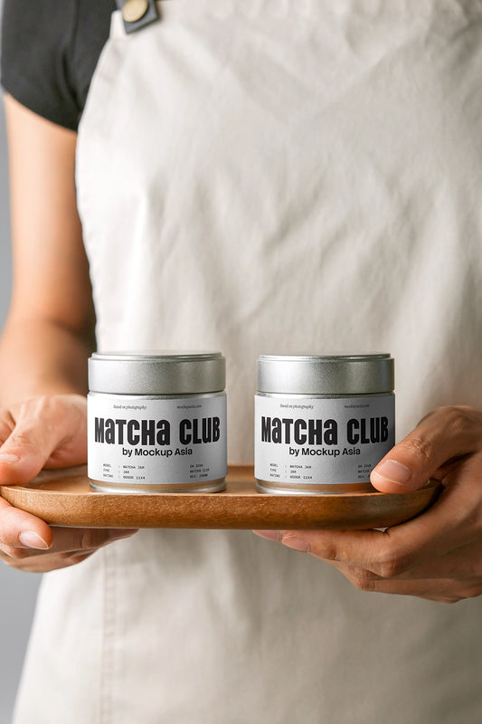 matcha tin mockup set held on wooden tray by hands, minimal lifestyle product presentation