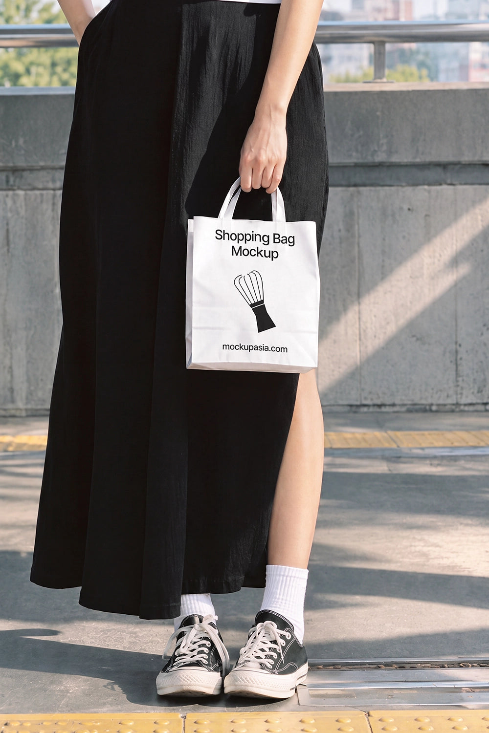 Small paper bag mockup PSD held by woman on city metro platform
