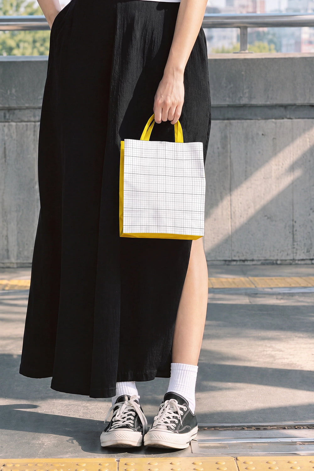 Paper bag mockup with editable accent color on concrete train station