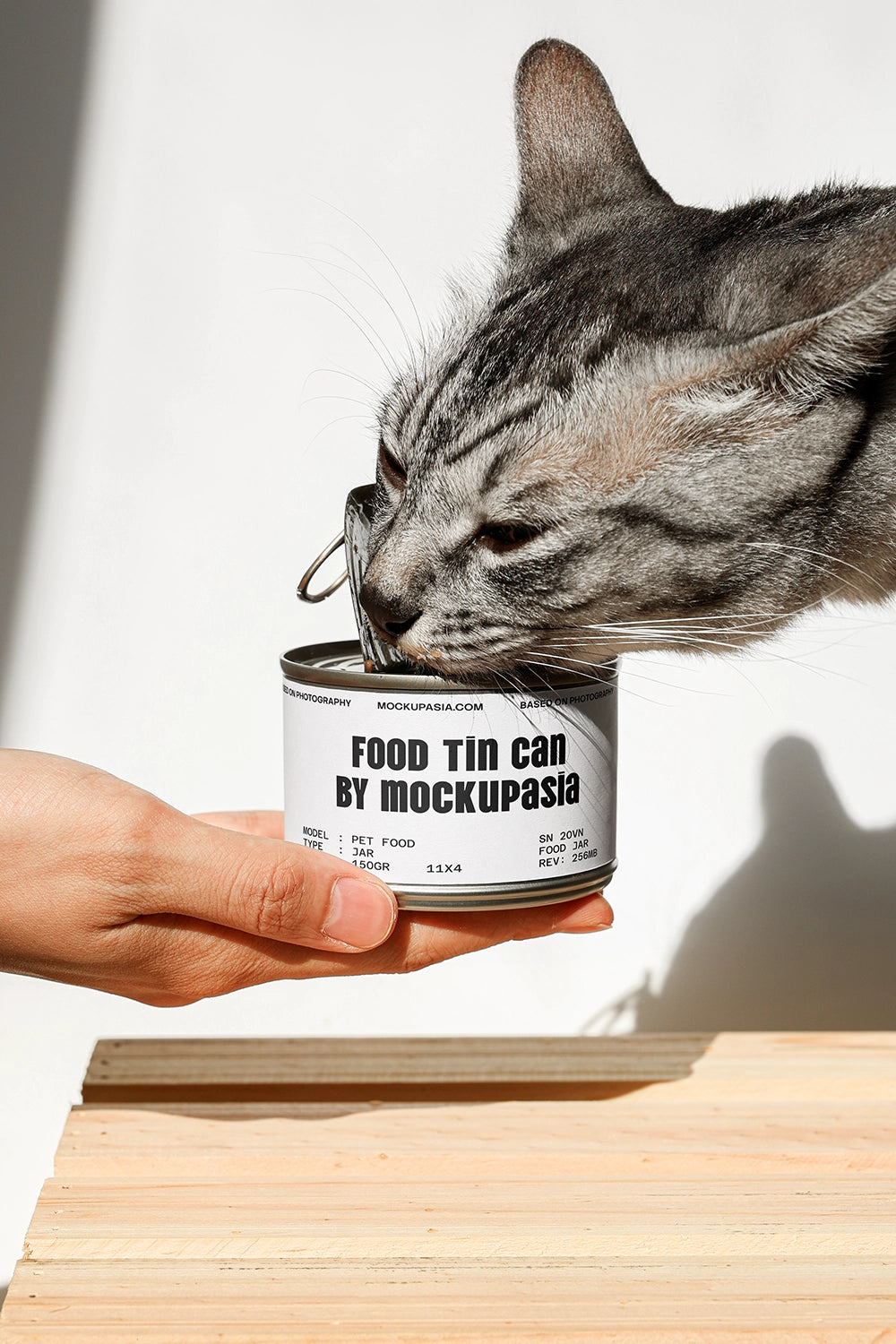 pet food tin can mockup held in hand with cat eating and realistic interaction scene
