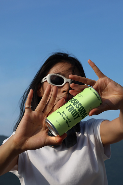 Aluminum beverage can mockup with dynamic hand interaction and natural lighting for branding presentation